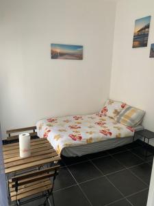 a bedroom with a bed and a wooden table at Jolie maisonnette avec terrasse Nancy centre in Nancy