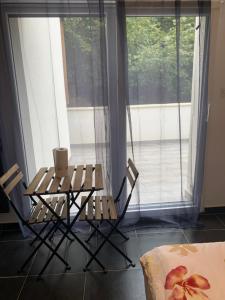 Jolie maisonnette avec terrasse Nancy centre في نانسي: طاولة وكراسي أمام النافذة