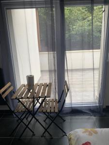 Jolie maisonnette avec terrasse Nancy centre في نانسي: طاولة وكرسيين أمام النافذة