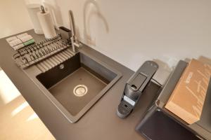 een aanrecht met een wastafel en een mobiele telefoon bij Dragon Residence in Ljubljana