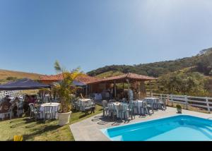 un restaurant avec des tables et des chaises ainsi qu'une piscine dans l'établissement sitio santa Eulalia, à Cunha