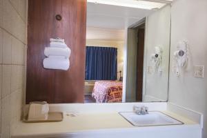 y baño con lavabo y espejo. en Centralia Motel near Downtown by OYO, en Centralia