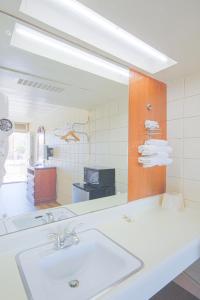 baño con lavabo y espejo grande en Centralia Motel near Downtown by OYO, en Centralia