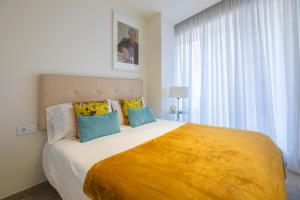 1 dormitorio con 1 cama grande con manta amarilla en Las Canteras Suite en Las Palmas de Gran Canaria