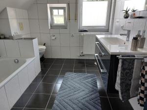 y baño con bañera, lavabo y aseo. en Villa FH Mechthild en Dörpen