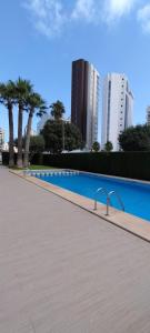 a large swimming pool with palm trees and buildings at Morello 1A in Calpe