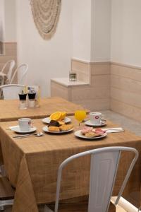 a table with two plates of food and a glass of orange juice at U-Sense For You Hostel Sevilla in Seville