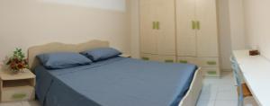 una piccola camera con letto blu e armadi di IN CENTRO APARTMENT a Melfi