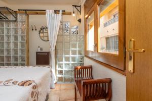 a bedroom with a bed and a chair and a window at Duna in Palamós