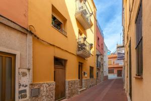 an alley in a city with a yellow building at Duna in Palamós