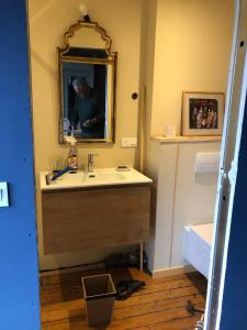 łazienka z umywalką i mężczyzną w lustrze w obiekcie La Touratte Bed & Breakfast w mieście Saint-Hubert