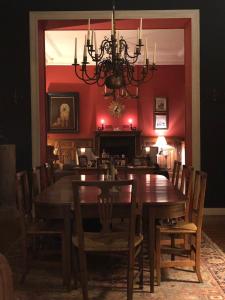 a dining room with a table and a chandelier at La Touratte Bed & Breakfast in Saint-Hubert