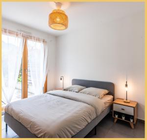 a bedroom with a large bed and a window at Appartement T2 Proche Genève Beaumont in Beaumont