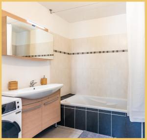 a bathroom with a sink and a bath tub at Appartement T2 Proche Genève Beaumont in Beaumont