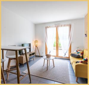 ein Wohnzimmer mit einem gelben Sofa und einem Tisch in der Unterkunft Appartement T2 Proche Genève Beaumont in Beaumont