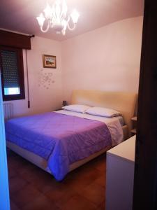 a bedroom with a bed with a purple blanket at Eureka Azienda Agrituristica in Cavallino-Treporti
