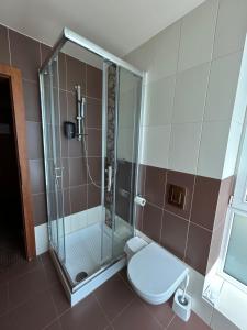 y baño con ducha y aseo. en Penzion Benedikti en Prievidza
