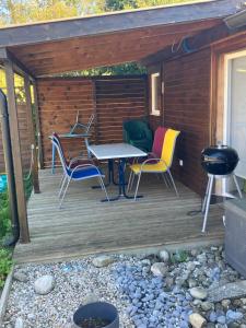 a wooden deck with chairs and a table and a grill at Pivert in Auvernier