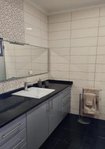 y baño con lavabo y espejo. en Ocean Breeze Apartment, en São Vicente