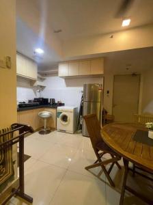 a kitchen with a table and a refrigerator at SGA SuriaJelutong in Shah Alam