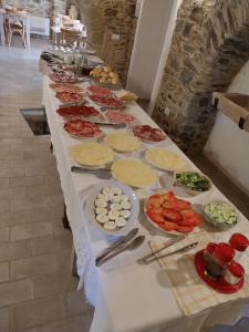 La Casa della Filanda في بيلمونتي كالابرو: طاولة طويلة مع العديد من أطباق الطعام عليها