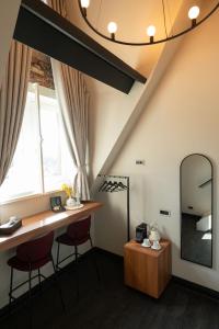 Habitación con tocador, 2 taburetes y espejo. en Hotel Kint en Valkenburg