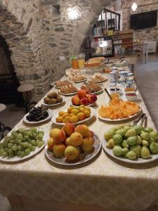 une table avec de nombreuses assiettes de fruits dans l'établissement La Casa della Filanda, à Belmonte Calabro
