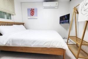 a bedroom with a bed with white sheets and a ladder at Hongdae Stn 2min 2R 1F #Core Stay 101 in Seoul