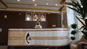 Un homme debout derrière un comptoir dans une pièce dans l'établissement Al Mukhtara Almasi Hotel, à Médine 7 autres photos