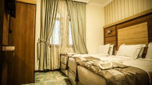 a hotel room with two beds and a window at Al Mokhtara Diamond in Medina