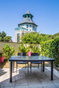 a blue table with two chairs in front of a building at Les maisons de Port Guillaume - maeva Home - Maison 3 Pièces 6 Personnes Sélection MAE-2279 in Dives-sur-Mer