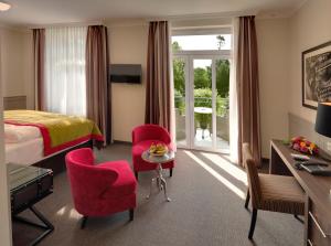 une chambre d'hôtel avec un lit, une table et des chaises dans l'établissement Hotel Max am Meer Kühlungsborn, à Kühlungsborn