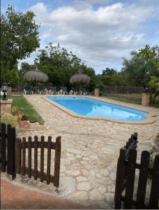 een zwembad in een tuin met een hek bij Finca Pili Mallorca in Felanitx