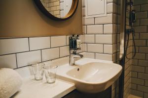 a bathroom with a sink and two glasses on a counter at The Knaresborough Inn - The Inn Collection Group in Knaresborough