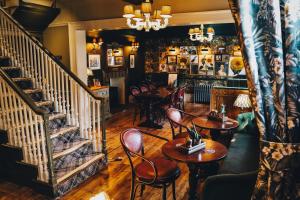 a restaurant with tables and chairs and a staircase at The Knaresborough Inn - The Inn Collection Group in Knaresborough