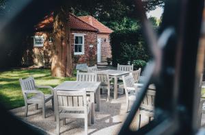 a group of white tables and chairs in front of a building at The Knaresborough Inn - The Inn Collection Group in Knaresborough