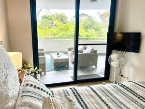 a bedroom with a bed and a view of a patio at Beachfront at Nautilus in Rockingham
