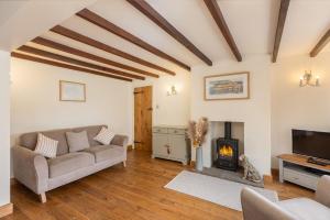 uma sala de estar com um sofá e uma lareira em Tillers Cottage - Stone Cottage set in quaint North Yorkshire Village em Ebberston