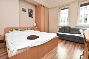 sypialnia z dużym łóżkiem i kanapą w obiekcie DUKES ApartHostel - pokoje prywatne, RYNEK we Wrocławiu