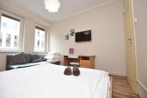 sypialnia z białym łóżkiem z butami w obiekcie DUKES ApartHostel - pokoje prywatne, RYNEK we Wrocławiu