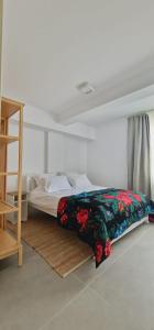 Un dormitorio con una cama con una manta floral. en Neo Rustic Bucovina, en Gura Humorului