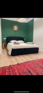 a bedroom with a large bed with a green wall at Charmant appartement in Ajaccio