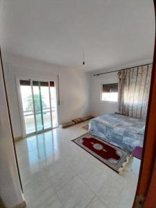 1 dormitorio con 1 cama en una habitación blanca en Maison Familiale à Oued Laou: Détente en Bord de Mer, en Oued Laou