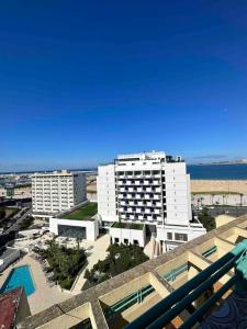 a view of a large white building and the ocean at Luxueux Appartement centre et plage & wifi ! in Tangier