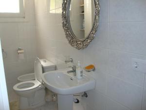 a bathroom with a toilet and a sink and a mirror at Apartments in a "VILLA VISTA JAVEA" in Jávea