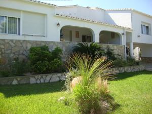 a house with a stone retaining wall in a yard at Apartments in a "VILLA VISTA JAVEA" in Jávea