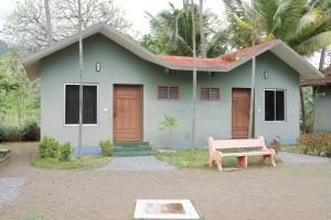 Kuttralam Resorts في كوتالام: منزل صغير أمامه جلسة وردية