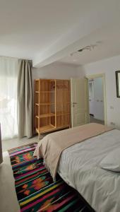a bedroom with a large bed and a rug at Neo Rustic Bucovina in Gura Humorului