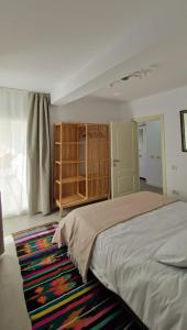 Un dormitorio con una cama grande y una alfombra. en Neo Rustic Bucovina, en Gura Humorului