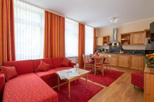 salon z czerwoną kanapą i kuchnią w obiekcie Ferienwohnungen Engelmannstift w mieście Bacharach